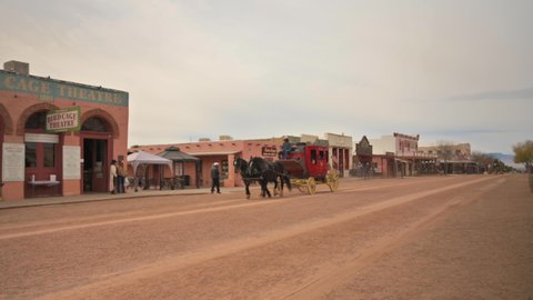 Tombstone , Arizona , United States - 12 22 2021: Horses with stagecoach got by Bird Cage Theatre in Tombstone, Arizona 