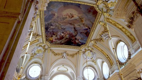 Royal Palace, Madrid, Spain - July 21 2019 : Numerous visitors admire the Interior Hall of the Royal residence majestically decorated with ceiling to wall paintings and tapestries.