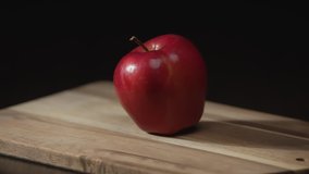 Slow motion. A large kitchen knife cuts a red apple into two pieces. A red apple on a black background. Close-up shooting. - Powered by Shutterstock - Get 15% off with code: PIKWIZARD15