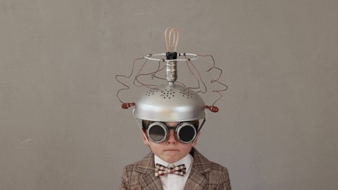 Smart child wearing handmade helmet with lightbulb. Funny kid having bright idea. Education and business concept. Slow motion 4K