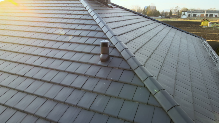 Closeup of ventilation pipe on house roof top covered with ceramic shingles. Tiled covering of building Royalty-Free Stock Footage #1084978249