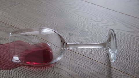 a glass of wine is lying on the floor. Wine spilled