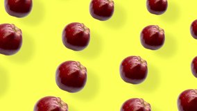 Colorful pattern of fresh red apples on yellow background with shadows. Seamless pattern with apple. Realistic animation. 4K video motion