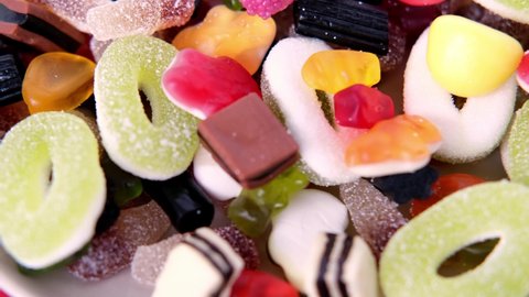 many colored gelatinous sweets, gummy bear, black licorice candies, concept of children's delicacy, healthy and unhealthy food, halal food, pleasant diet, selective focus at shallow depth of field