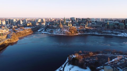 Aerial view of Parliament Hill in Ottawa Canada in early winter at sunset with the icy Ottawa river