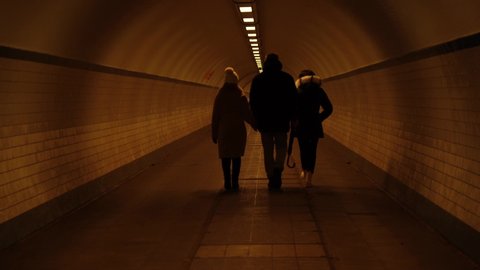 A family walking in a tunnel side by side