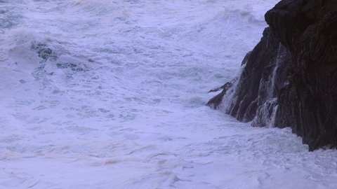 Ocean waves hitting against the rocks on a stormy day - travel photography