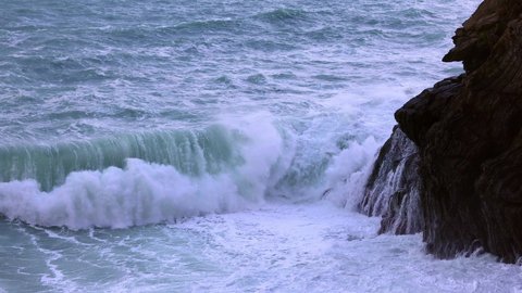 Ocean waves hitting against the rocks on a stormy day - travel photography