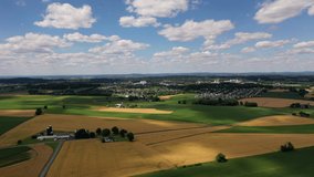 Aerial Slow Pan 4K Video of Farmland and Suburbs with Bright Blue Sky and Clouds