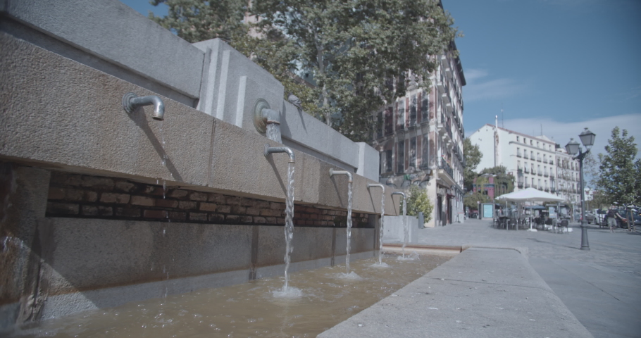 Travel and architecture series. View of a fountain in the neighborhood of La Latina, on a summer afternoon in Madrid, Spain, with a blue sky and white clouds perfect for a romantic weekend getaway