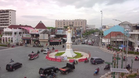 Jogjakarta, Indonesia - Dec 14, 2021: Busy Morning Street At White Paal (Tugu Jogja) an Icon of Jogja 