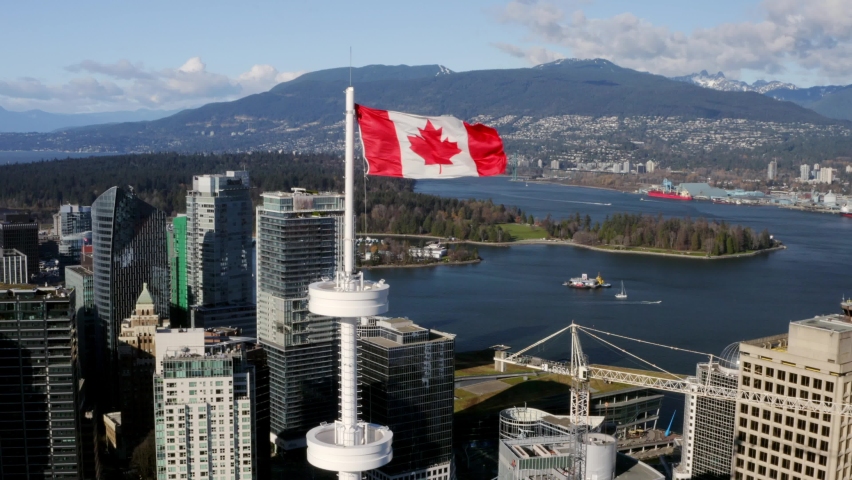 Aerial View Of Canadian Flag Waving In The Wind At Vancouver Lookout In Harbour Centre In Canada. - pullback