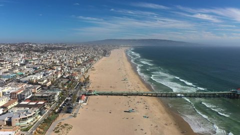 Aerial View Of People At The Beach With Manhattan Beach Pier By The Blue Sea In California, USA.