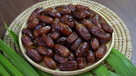 Dried  date palm fruit on a wooden plate, Rotation Sweet date palm fruit.