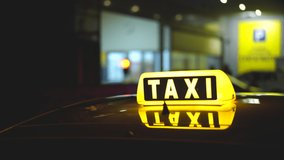 Close-up view on LED illuminated lights of TAXI sign on top of cab car. Driver stopped, waits for passengers, clients. Late evening hours service. Yellow color neon glowing. Twilight city streets taxi - Powered by Shutterstock - Get 15% off with code: PIKWIZARD15