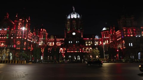 Mumbai, Maharashtra, India - 3rd Jan, 2022 : Real time still video of vehicle traffic outside Chhatrapati Shivaji Terminus (CST) Railway station at night. UNESCO Heritage site illuminated with lights.