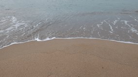 Waves breaking on the beach. Wavy calm sea and sandy beach. Summer or vacation 4k background video.