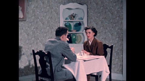 1950s: A couple sits at a table in a restaurant and look at the menu. Waiter in a naval costume reaches in a pocket for a pen. Couple sets aside the menus. Slate. Invitation to a dinner party.