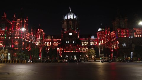 Mumbai, Maharashtra, India - 3rd Jan, 2022 : Real time still video of vehicle traffic outside Chhatrapati Shivaji Terminus (CST) Railway station at night. UNESCO Heritage site illuminated with lights.
