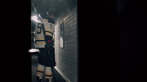 Ice hockey player is disappointed with the game results, raging in the hallway room during the intermission. Shoot with 2x anamorphic lens