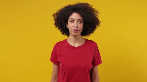 Excited jubilant overjoyed happy charismatic young black woman 20s years old wear red t-shirt doing winner gesture celebrate clenching fists say yes isolated on plain yellow background studio portrait