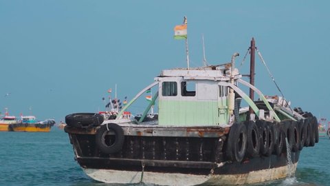 Slow motion shot of boat sailing in ocean with Indian flag waving on boat. At Okha Port in Okha, Gujarat, India. Concept of transportation in sea. Passenger boat during holidays. 