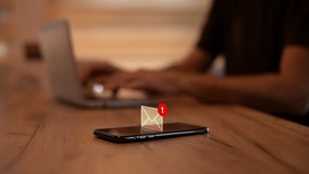 Text message notification pops up on mobile smart phone in home office, man typing laptop computer, selective focus - Powered by Shutterstock - Get 15% off with code: PIKWIZARD15