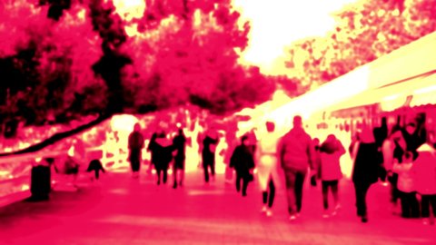 Park pedestrian street. A lot of passers-by and walking on a sunny autumn day. Surrealistic art infrared spectrum. Blurred unrecognizable people.