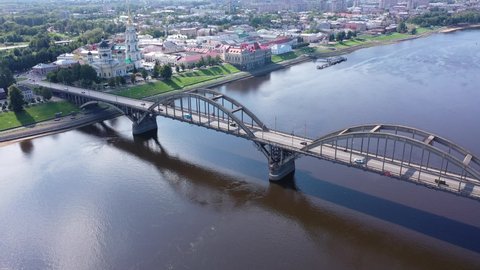 Aerial panoramic view of Rybinsk cityscape overlooking automobile bridge across Volga river and medieval Spaso-Preobrazhensky Cathedral with belfry in historical part of city, Yaroslavl region