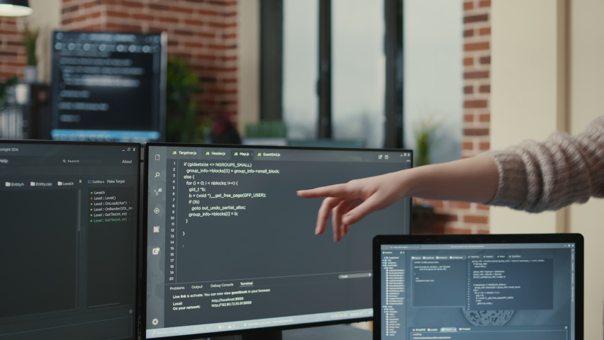 Programmer analyzing compiling code on multiple screens takes off glasses and doing high five hand gesture with colleague developer. Software developers celebrating successful coding. Royalty-Free Stock Footage #1085102060