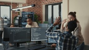 Programmer analyzing compiling code on multiple screens takes off glasses and doing high five hand gesture with colleague developer. Software developers celebrating successful coding. - Powered by Shutterstock - Get 15% off with code: PIKWIZARD15
