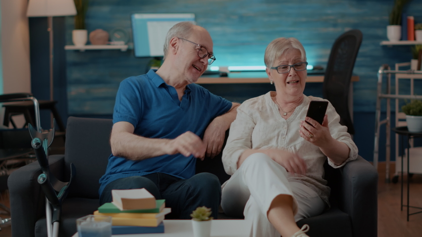 Retired couple talking to family on remote video call, using smartphone for telecommunication. Elderly man and woman chatting on online teleconference call. Internet discussion Royalty-Free Stock Footage #1085102159
