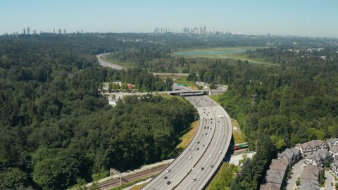 Aerial drone view over the Trans-Canada Highway in Burnaby with the Vancouver skyline in the distance.