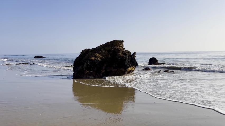 view of the ocean with Waves rolling at a sandy beach in Malibu California during a sunny afternoon