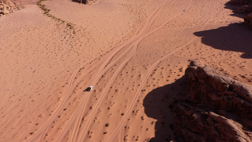 Aerial shot from above with group of people driving in off road vehicle in the middle of the Wadi Rum desert, Jordan Royalty-Free Stock Footage #1085118068