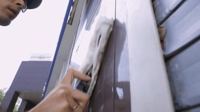 Close-up video of a cleaning service specialist washes and cleans the windows and facade of the building