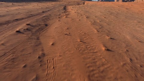 FPV chasing a 4x4 with tourists during the sunrise in the desert of Wadi Rum, Jordan