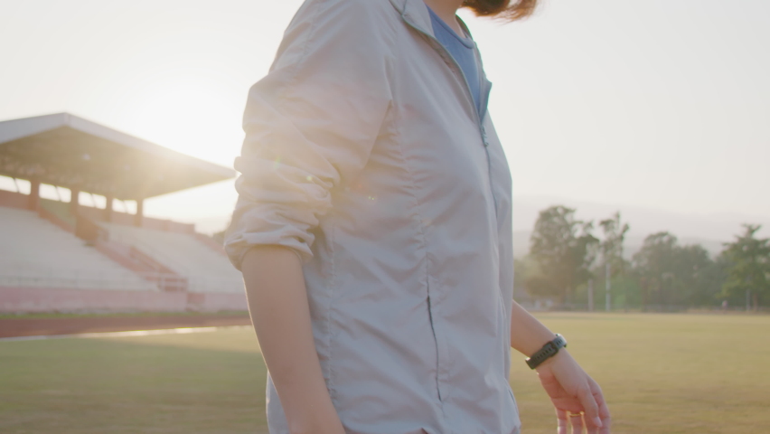 Young woman walking happily on the lawn,exercise and healthy concept.