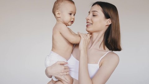 Storytelling footage of mothers posing in studio for a body positive beauty set. Pregnant young women and their children on colored backgrounds. Concept about pregnancy and motherhood
