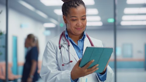 Medical Hospital Portrait: Professional African American Female Medical Doctor Using Digital Tablet Computer. Health Care Black Physician in White Lab Coat Prescribes Medicine, Ready to Save Lives