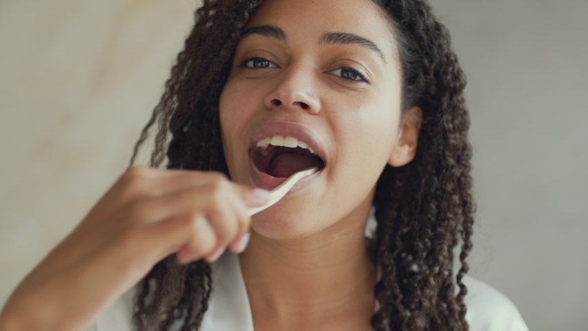 Deep teeth cleaning. Mirror pov portrait of young black lady brushing her teeth with toothbrush, caring about her dental hygiene at home in morning, slow motion | Shutterstock HD Video #1085134730