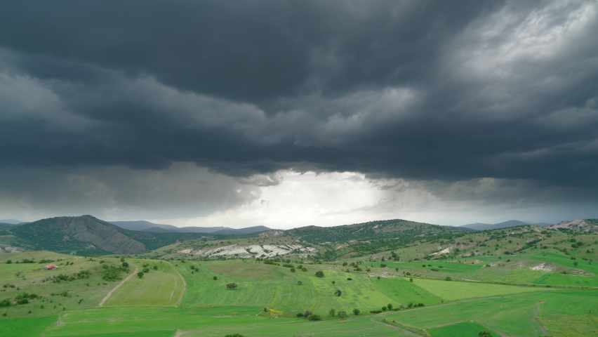 8K 7680X4320 4320p.Storm clouds over meadow moorland.Dark stormy cloud over green field.Weather before and after the tempestuous.Black grey cumulonimbus tempest low high pressure nature time lapse 8K.