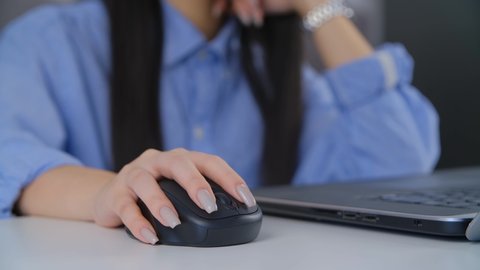 Freelancer woman clicking with wireless mouse. Young girl working freelance from home on lockdown. New normal and distant online work concept filmed in 4K stock video. Free lance concept footage