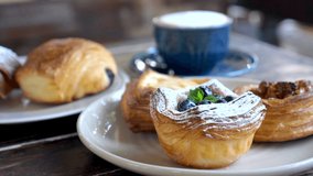 Sweet danish pastries. Puff pastry, fresh buns with powdered sugar, berries, caramel and chocolate. Tasty bakery on plates and cup of coffee. Breakfast in rustic cafe with freshly baked bun - Powered by Shutterstock - Get 15% off with code: PIKWIZARD15