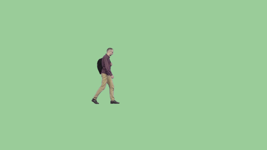 An adult man with a backpack walks through the frame. Alpha channel background