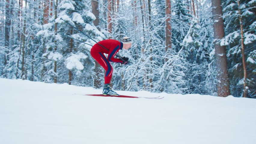 Cross country ski. Young fit man in red ski suit skiing in the winter forest Royalty-Free Stock Footage #1085142995