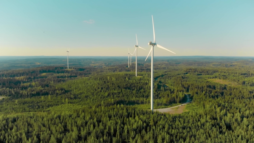 Aerial drone view of Finland forest landscape and wind turbines generating clean renewable energy. Wind farm and green electricity production in Europe and nordic countries.