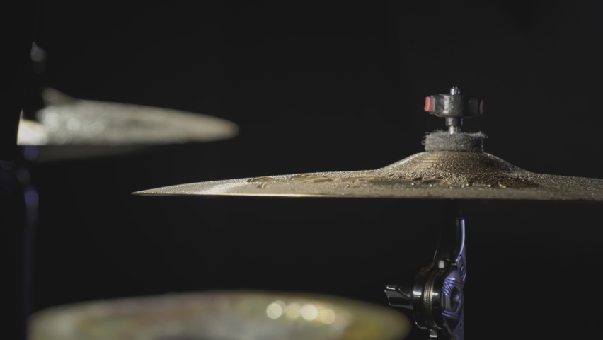 The drummer hits the wet drum cymbal with his drumstick and the water splashes in slow motion. In the recording studio of musical instruments. Knocks and beats, Repetition of rock music band. Royalty-Free Stock Footage #1085146343