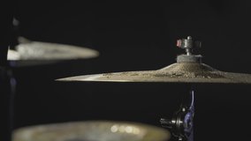 The drummer hits the wet drum cymbal with his drumstick and the water splashes in slow motion. In the recording studio of musical instruments. Knocks and beats, Repetition of rock music band.