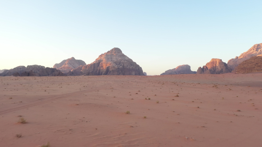 Aerial footage of Wadi Rum desert in Jordan during a beautiful sunrise with the red rocks in the background Royalty-Free Stock Footage #1085148362